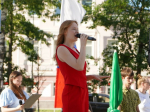 Участница фестиваля молодежного творчества «Каменный мост» с микрофоном в руках на проспекте Победы..